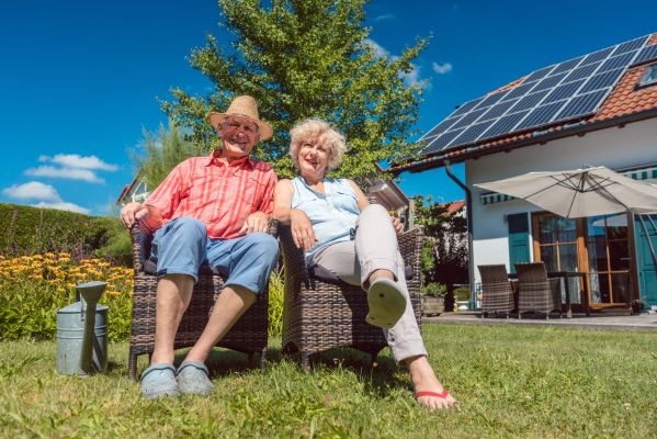 Rentnerehepaar vor Haus mit Photovoltaik