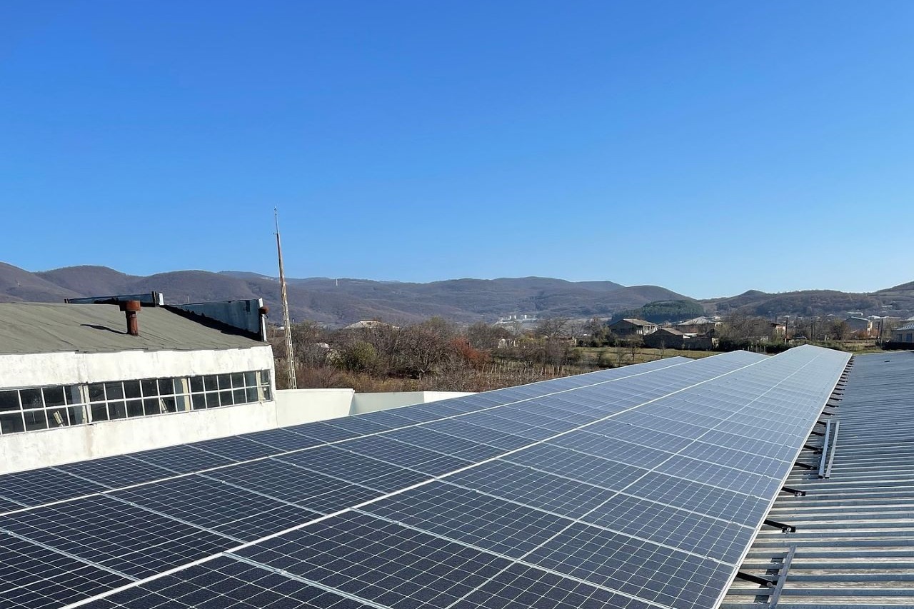 Solarpanele auf einem Dach vor Bergpanorama